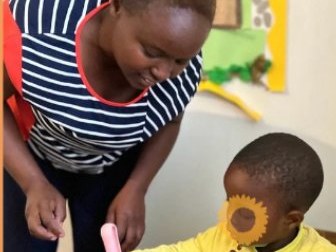 A teacher helping a child learn to write